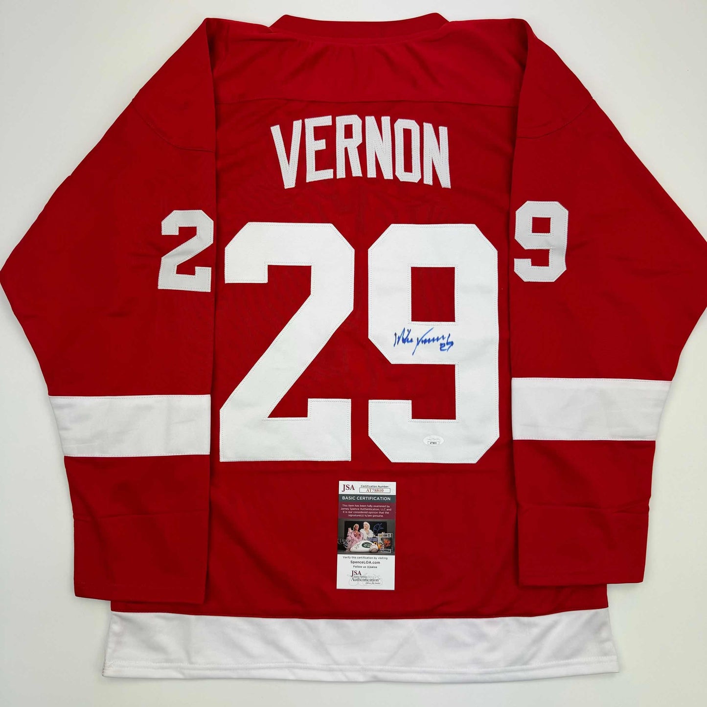 Red Detroit Red Wings hockey jersey with white number 29 and "VERNON" nameplate, displayed flat showing back with JSA authentication certificate.
