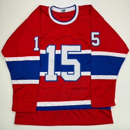 Red, white, and blue striped Montreal Canadiens hockey jersey with number 15 displayed flat against white background.