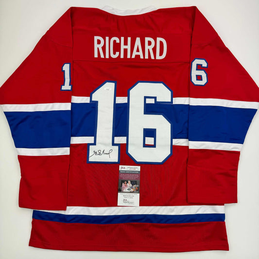 Red, white, and blue Montreal Canadiens hockey jersey #16 displaying "RICHARD" nameplate and JSA authentication certificate on back view.
