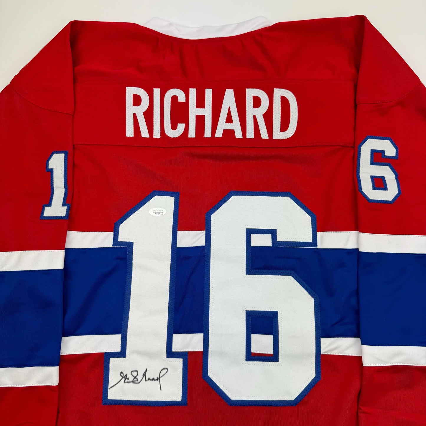 Back view of red, white and blue Montreal Canadiens hockey jersey with "RICHARD" and numbers "1" and "6" visible, displaying signed number "15" on white chest panel.