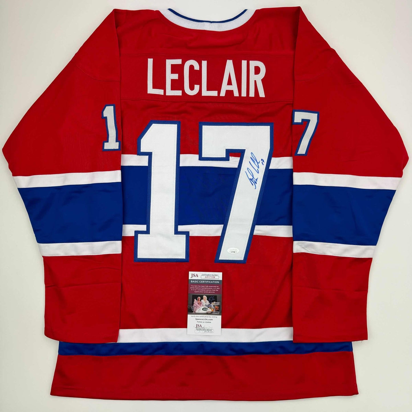 Signed Montreal Canadiens jersey number 17 displayed flat, showing red, white and blue stripes with LeClair name and JSA authentication label.