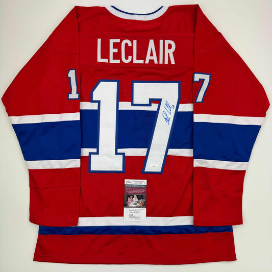Signed Montreal Canadiens jersey number 17 displayed flat, showing red, white and blue stripes with LeClair name and JSA authentication label.