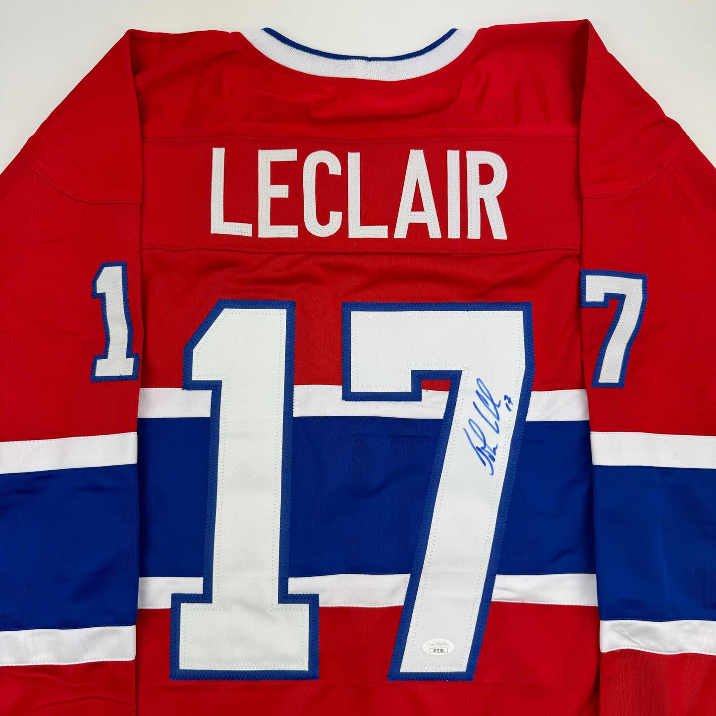 Back view of red, white, and blue Montreal Canadiens hockey jersey with LeClair name and number 17, displaying player signature on chest.