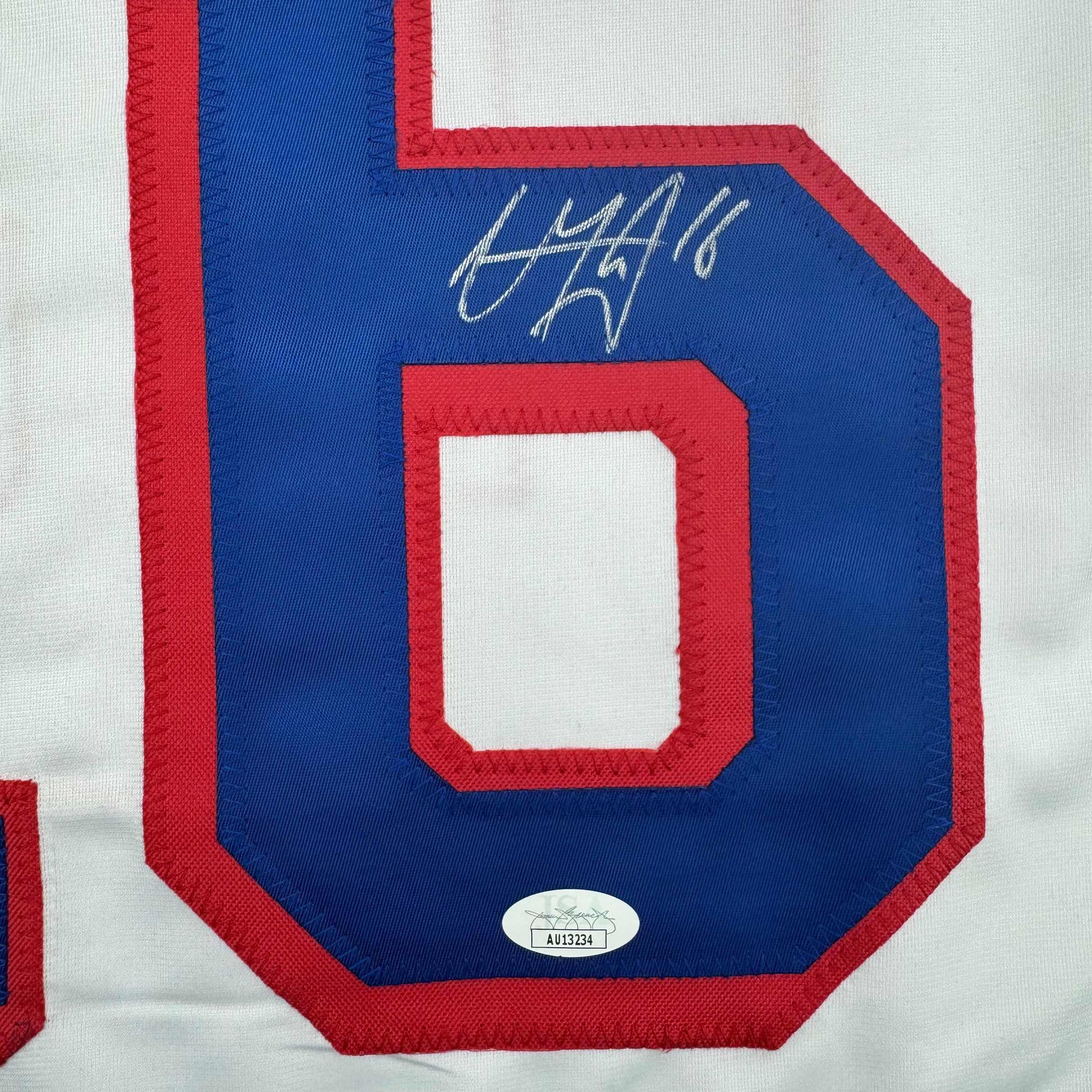 Close-up of blue jersey number 6 with red trim and handwritten autograph, showing JSA authentication sticker.