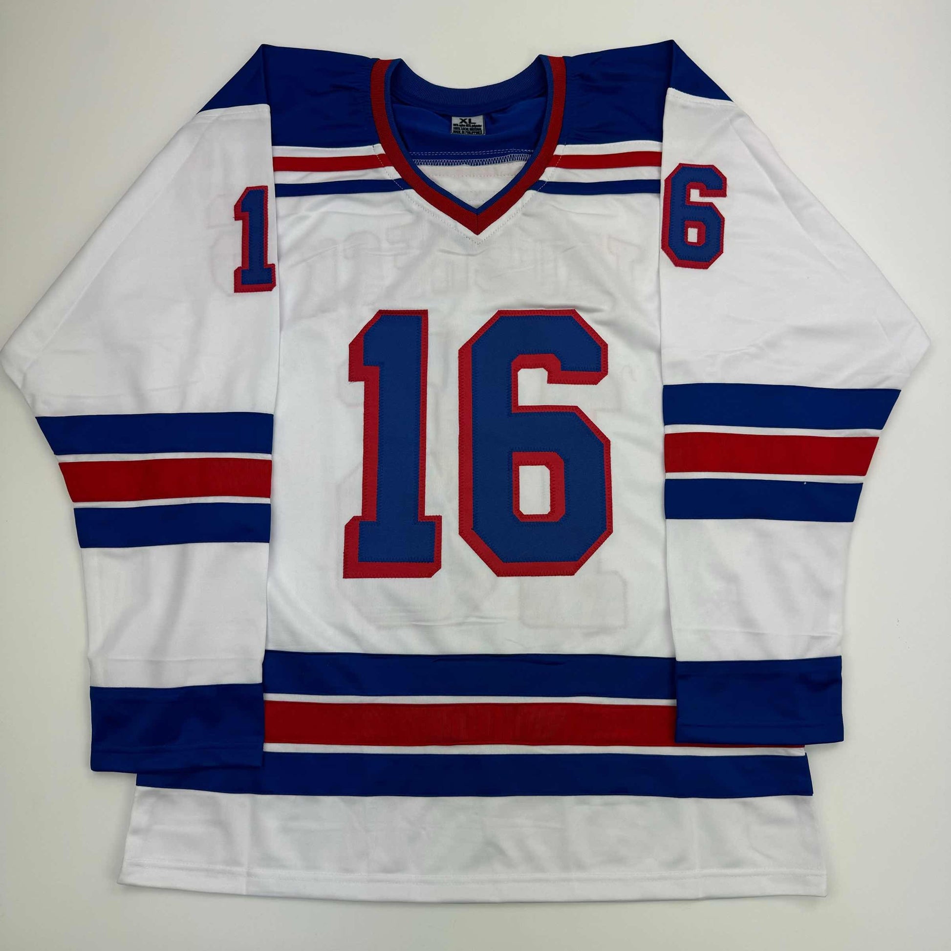 White hockey jersey with blue and red horizontal stripes, large red number 16 on chest, small red number 16 on shoulder, laid flat on white background.