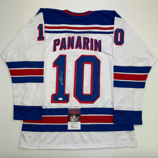 White hockey jersey with navy and red horizontal stripes displaying "PANARIN" and number 10, with JSA authentication certificate attached.