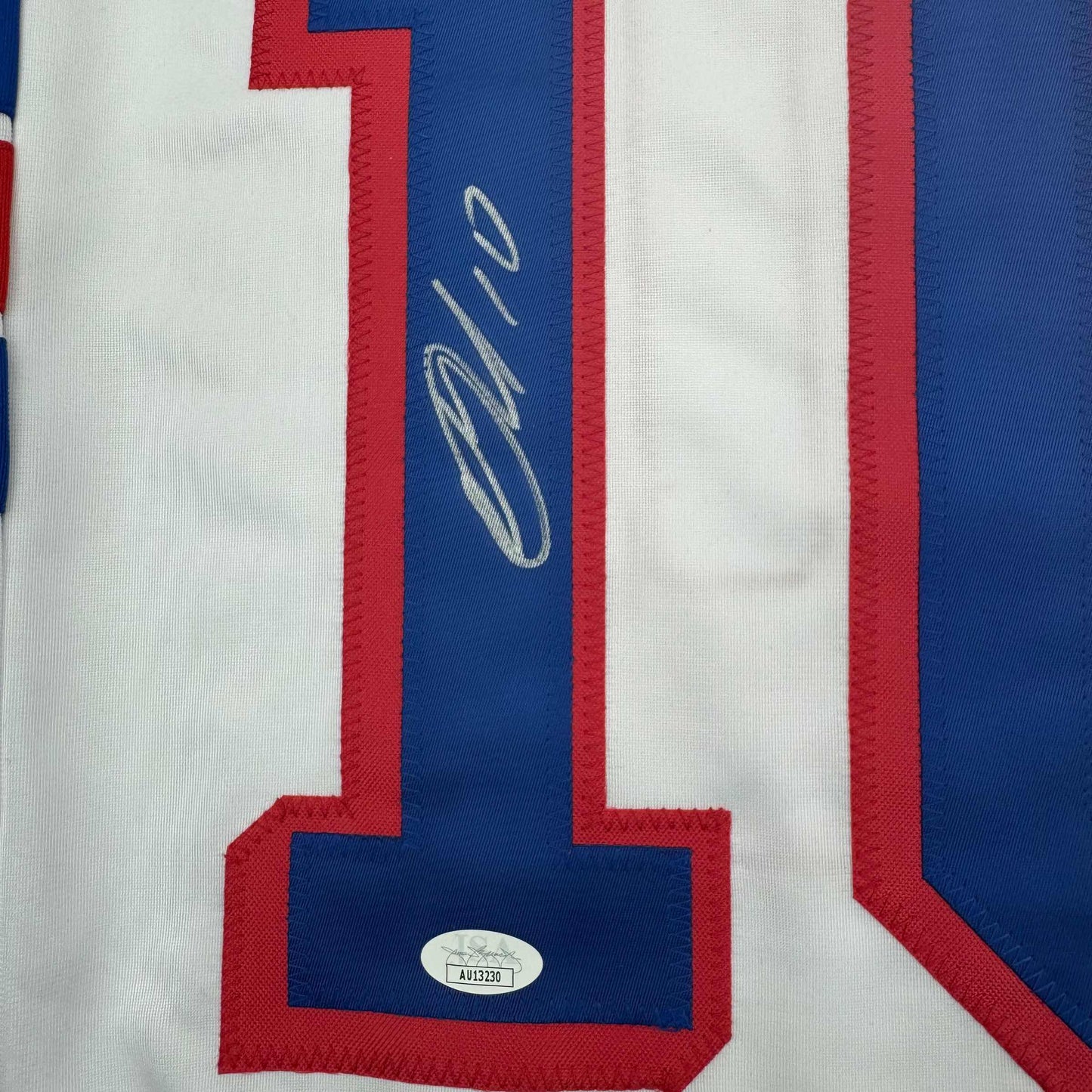 Close-up of signed blue stripe on white and red striped hockey jersey with JSA authentication sticker visible.
