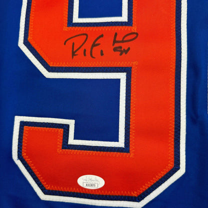 Close-up of signed Edmonton Oilers hockey jersey showing red and blue panel with handwritten signature and JSA authentication sticker.