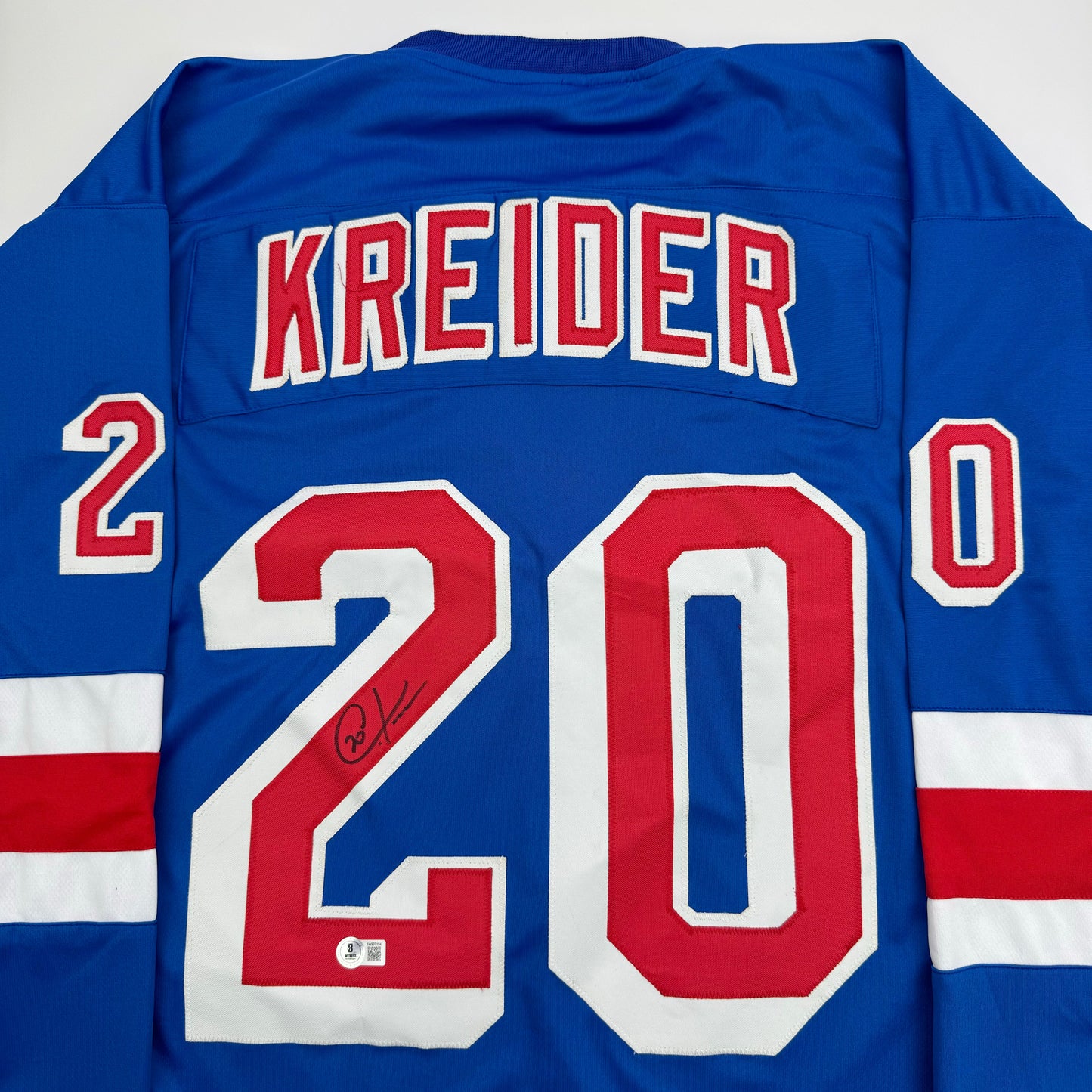 Blue New York Rangers hockey jersey with "KREIDER" and number 20 displayed on back, featuring red and white stripes, with visible autograph on the number.