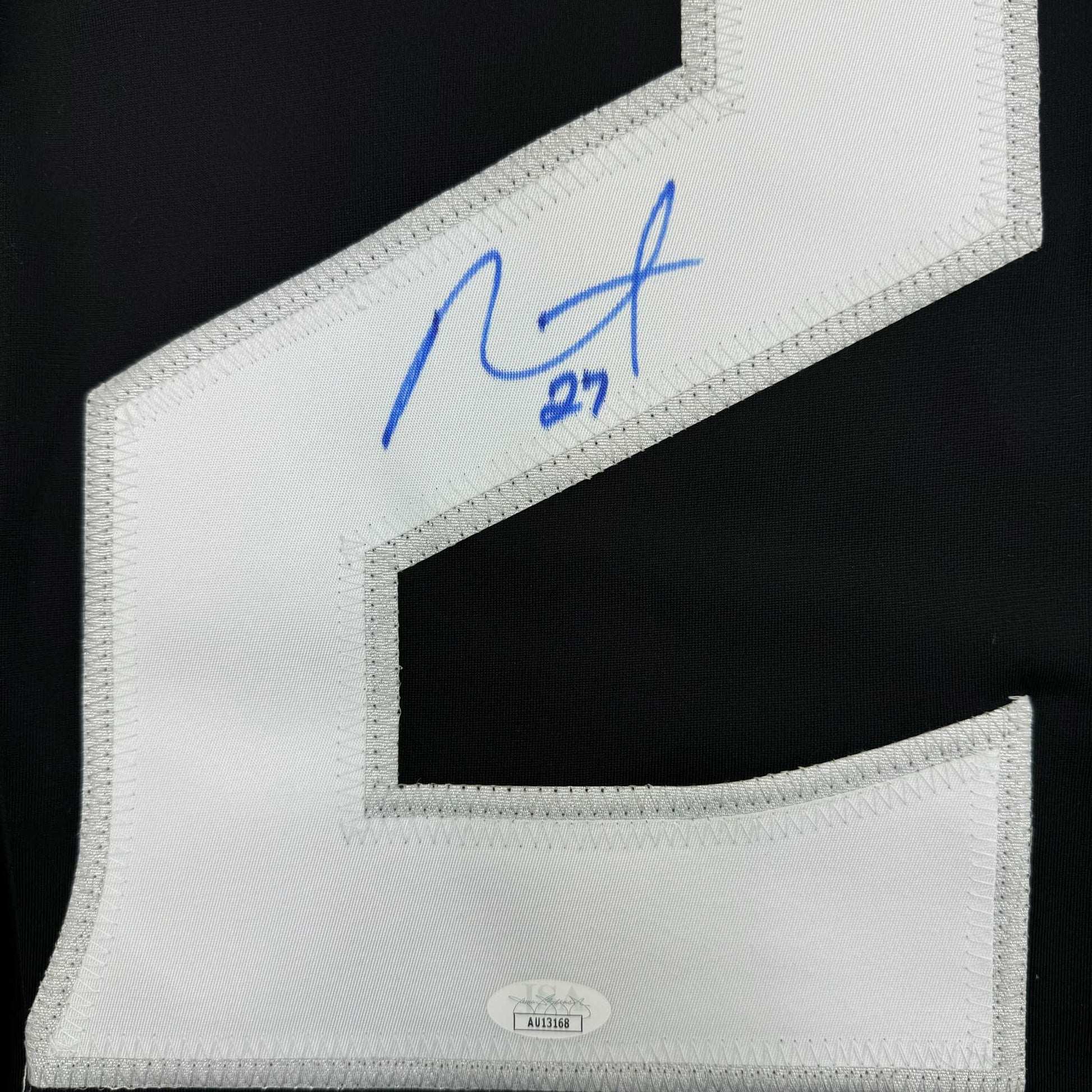 Close-up of white jersey collar showing blue autograph reading "Alec" with "#27" and JSA authentication label at bottom.
