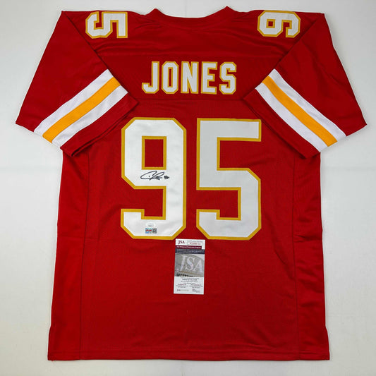 Red Kansas City Chiefs jersey number 95 with "JONES" nameplate, displayed flat with JSA authentication certificate visible at bottom.