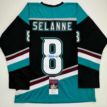 Back view of black Anaheim Ducks hockey jersey number 8 with teal and white striping, signed by Teemu Selanne, with JSA authentication certificate visible.