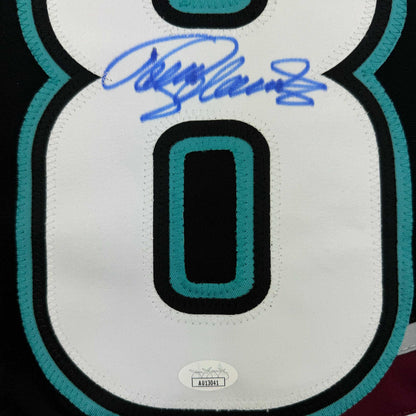 Close-up of signed Anaheim Ducks retro hockey jersey front showing number zero, teal and black trim, with blue autograph and authentication label.