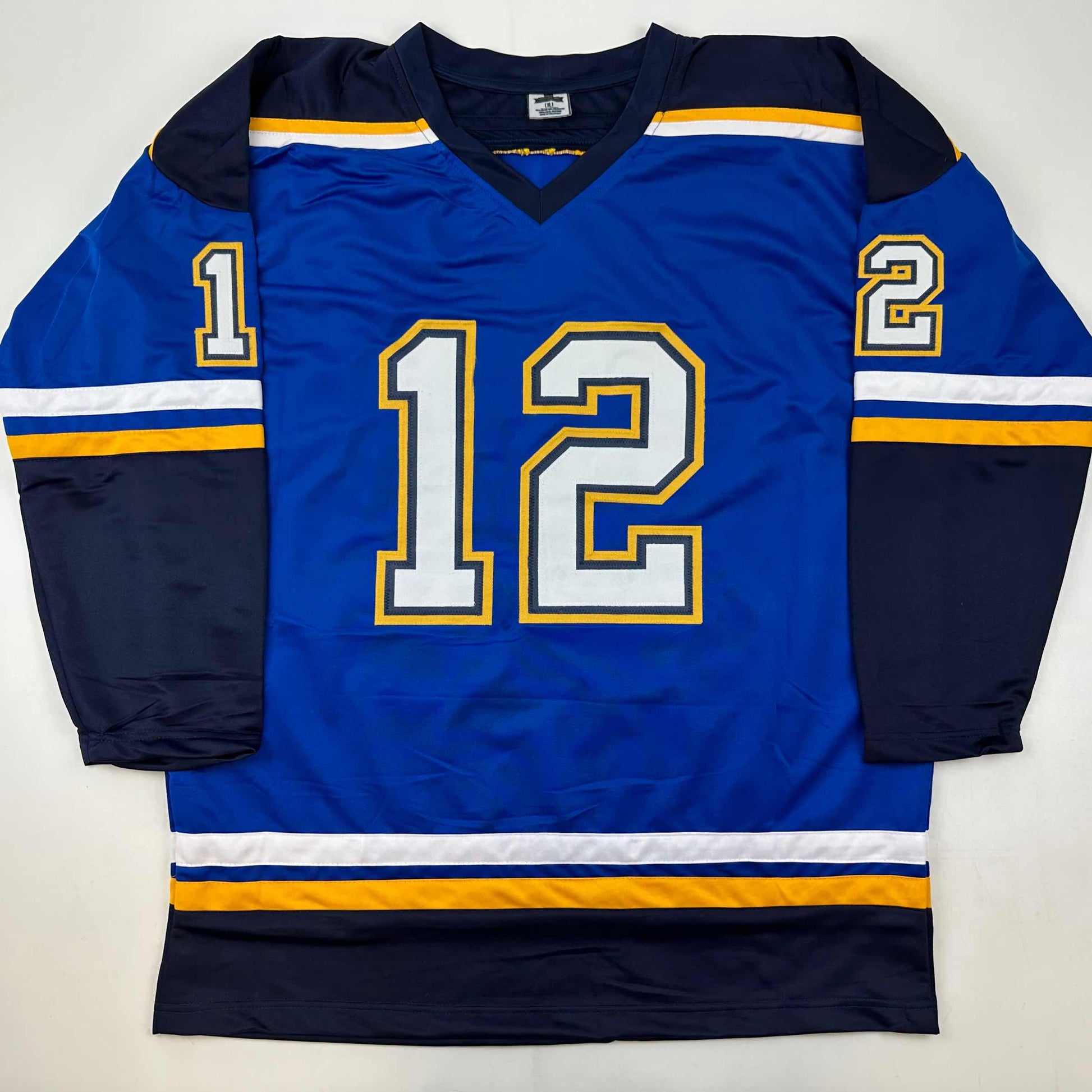 Blue hockey jersey with white and gold number 12, displayed flat on white background showing front view and sleeves.