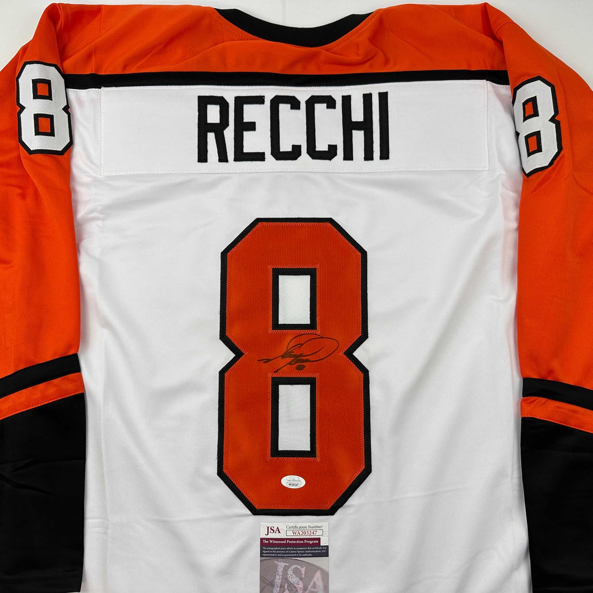 Back view of white Philadelphia Flyers hockey jersey number 8 with "RECCHI" nameplate and autographed number, orange sleeves, JSA authentication certificate visible at bottom.