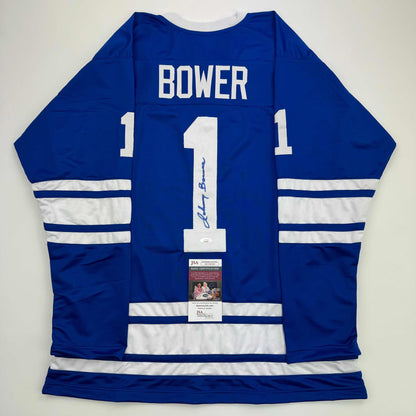 Back view of signed blue and white Toronto Maple Leafs hockey jersey number 1 with Bower name and JSA authentication certificate.