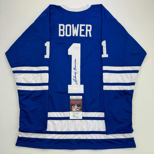 Back view of signed blue and white Toronto Maple Leafs hockey jersey number 1 with Bower name and JSA authentication certificate.