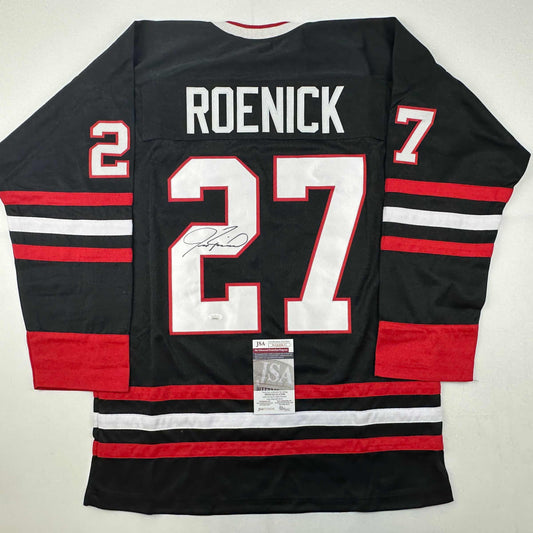 Back view of black hockey jersey with red and white horizontal stripes, "ROENICK" and number 27 with signature and JSA authentication label.