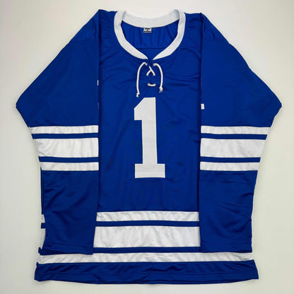 Blue and white hockey jersey with number 1 displayed flat against white background, showing front view with lace-up neckline and striped sleeves.
