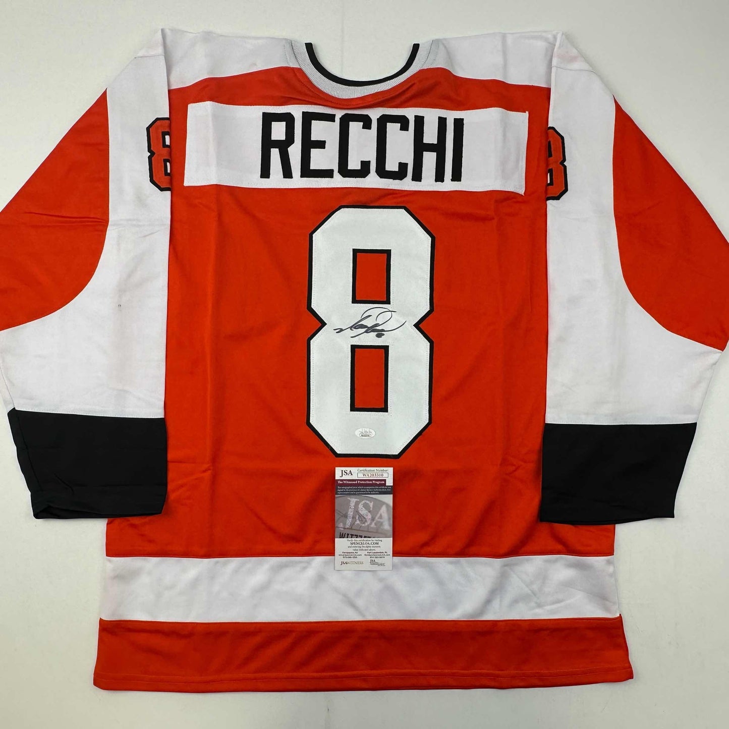 Signed Philadelphia Flyers hockey jersey number 8 with Recchi name displayed flat, showing red, white, and black striped design with JSA authentication certificate.