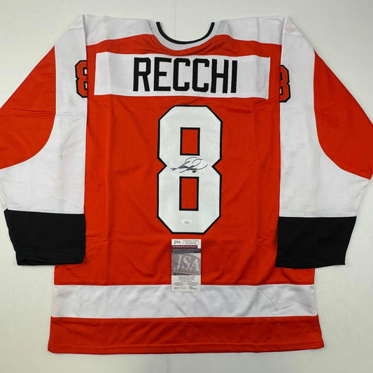 Signed Philadelphia Flyers hockey jersey number 8 with Recchi name displayed flat, showing red, white, and black striped design with JSA authentication certificate.