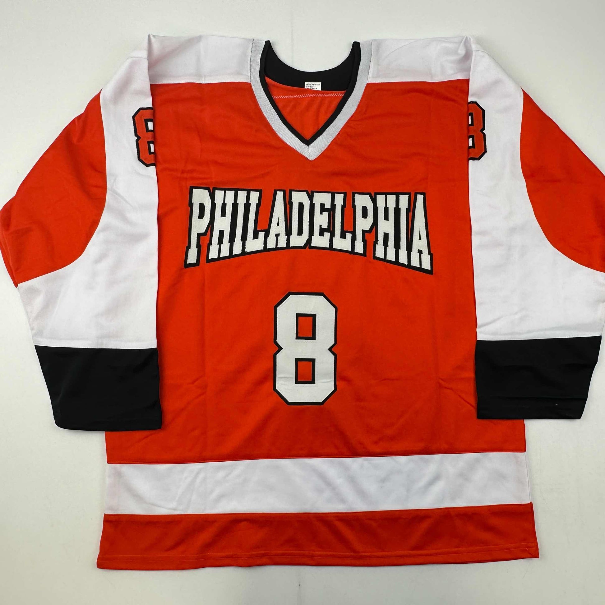 Red, white, and black Philadelphia hockey jersey number 8 laid flat against white background, front view.