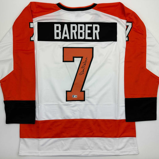 Back view of signed Bill Barber Philadelphia Flyers white hockey jersey displaying number 7 and nameplate.
