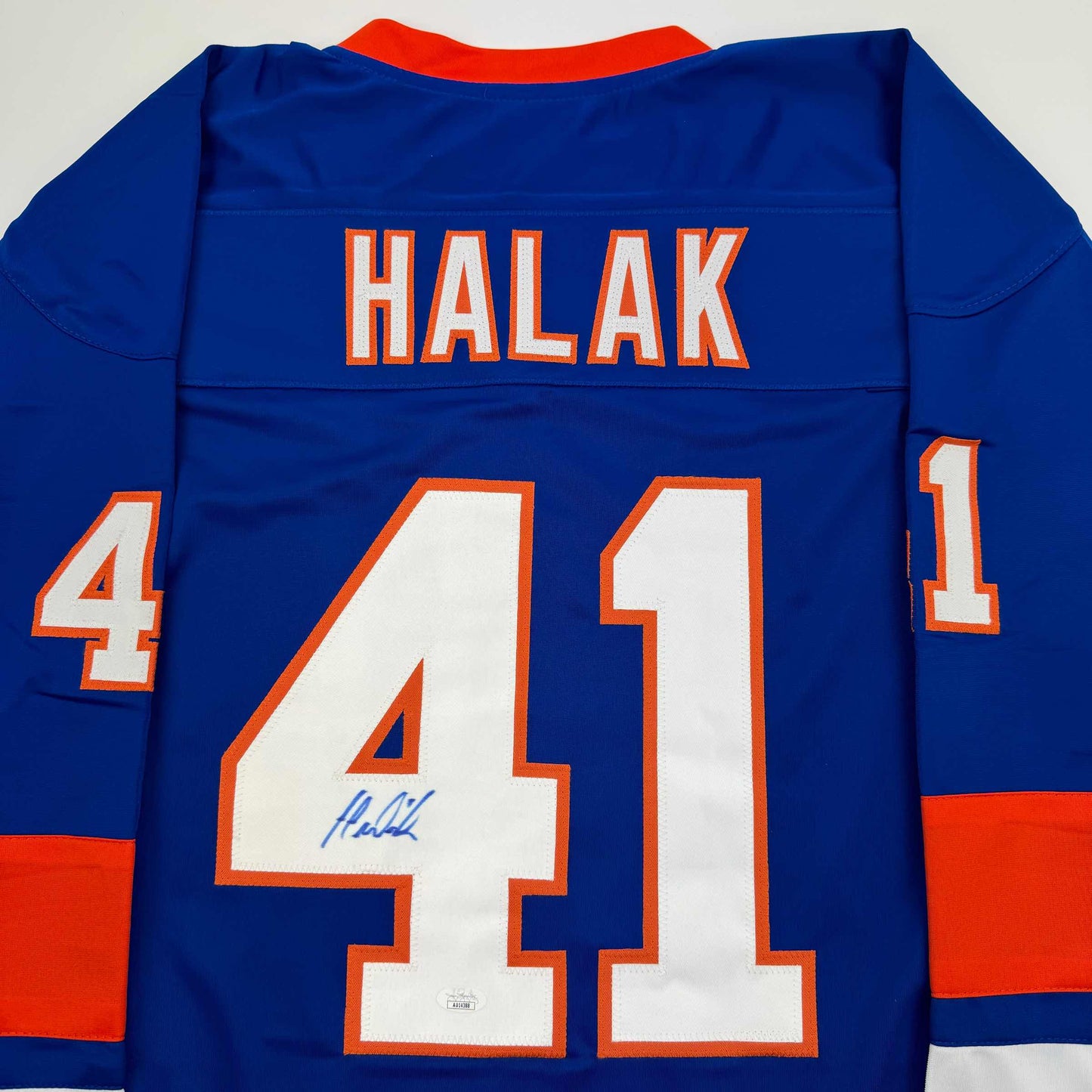 Back view of blue hockey jersey with "HALAK" and number "41" in orange and white, signed in blue ink on the number.