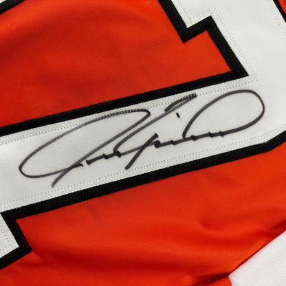 Close-up of Jeremy Roenick's autographed signature on white stripe of orange, white, and black hockey jersey.