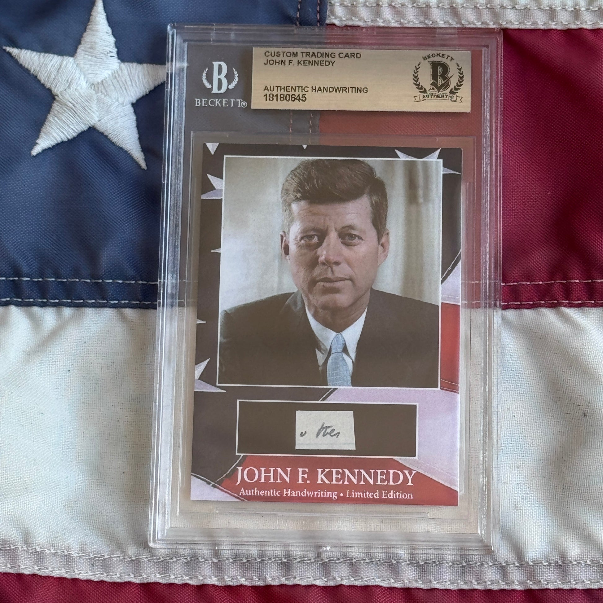 Beckett-authenticated John F. Kennedy trading card with handwritten signature displayed against American flag background.
