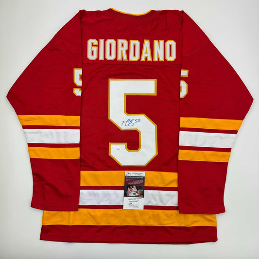 Red Calgary Flames hockey jersey number 5 with "GIORDANO" nameplate, displayed flat with JSA authentication certificate visible at center.