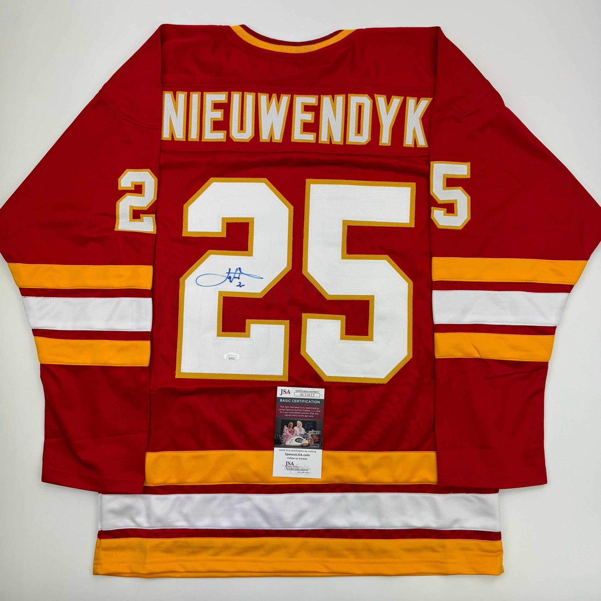 Red Calgary hockey jersey number 25 with "NIEUWENDYK" nameplate, signed in blue ink, displayed flat with JSA authentication label visible.