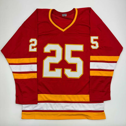Red hockey jersey with white and gold number 25, gold and white striped sleeves, displayed flat against white background.