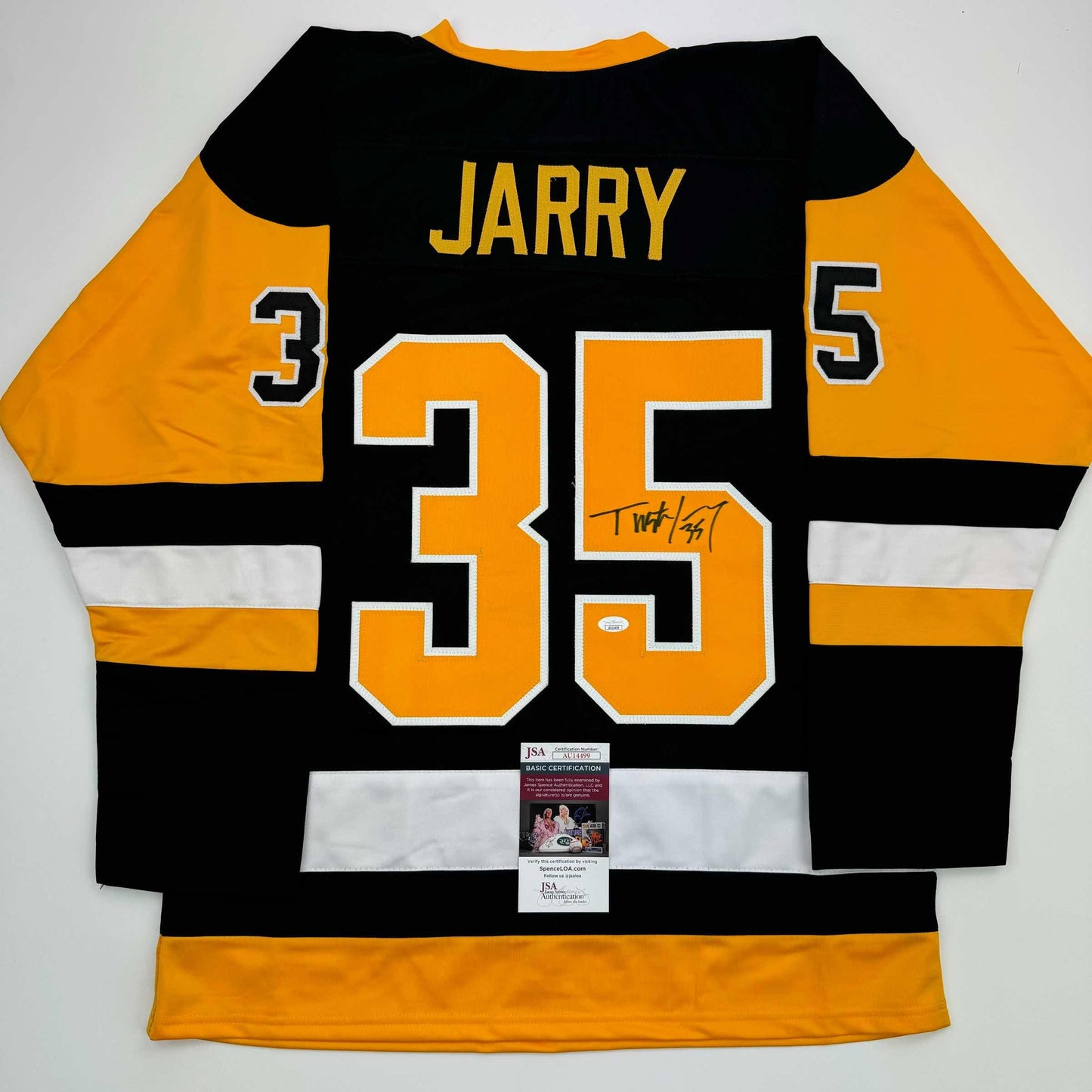 Back view of black and gold Pittsburgh hockey jersey numbered 35 with "JARRY" nameplate, signed in black marker, with JSA authentication certificate attached.