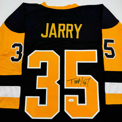 Back view of black and gold hockey jersey with "JARRY" and number 35 in orange with white trim, signed in black marker.
