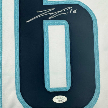 Close-up of navy hockey jersey back with turquoise trim, white number zero panel, silver signature reading "2016" and JSA authentication sticker.