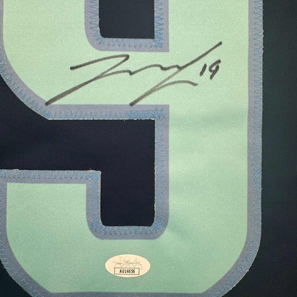 Close-up of mint green hockey jersey back showing black mesh panels, gray binding, handwritten signature, and JSA authentication label.