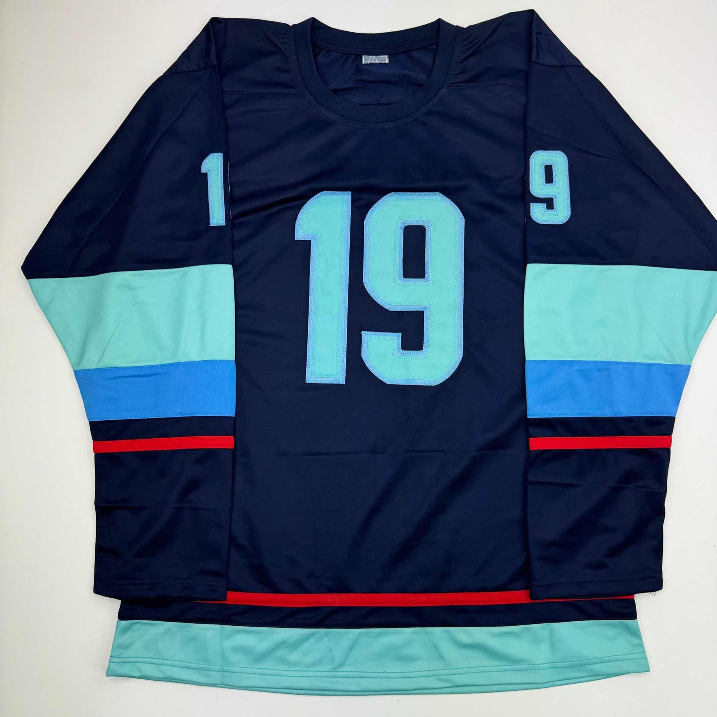 Navy hockey jersey with light blue number 19, displayed flat showing front view with mint green and blue striped sleeves and red accent stripes.