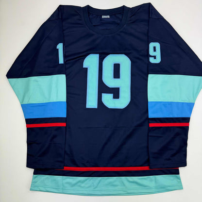 Navy hockey jersey with light blue number 19, displayed flat showing front view with mint green and blue striped sleeves and red accent stripes.
