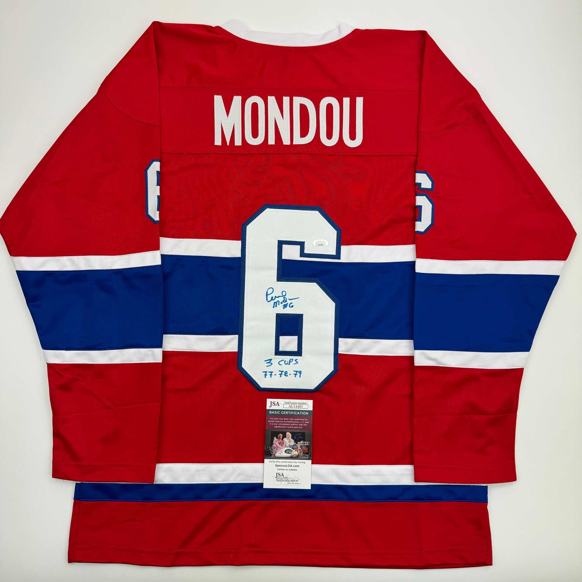 Red, white, and blue Montreal Canadiens hockey jersey displayed flat, showing back with "MONDOU" and number 5, signed with "3 CUPS 77-78-79" notation and JSA certification label.