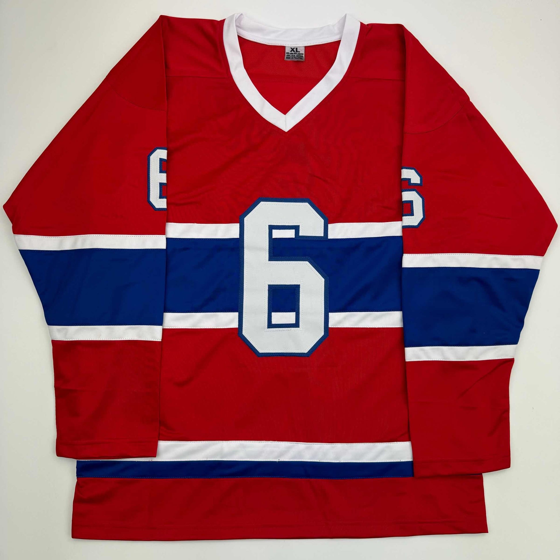 Red, white, and blue striped Montreal Canadiens hockey jersey with number 6 displayed flat against white background.