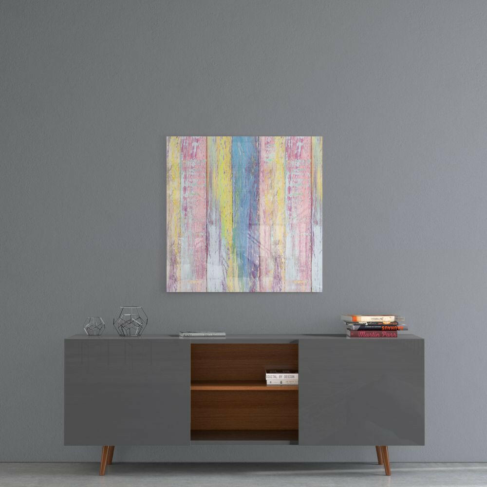Colorful pastel striped glass art with pink, yellow, blue, and white vertical planks displayed above a gray mid-century modern credenza.