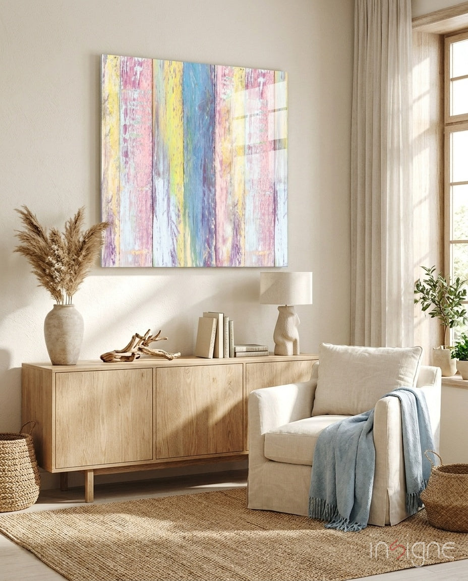 Colorful wooden patterned glass wall art with pastel pink, yellow, and blue vertical stripes displayed above a light wood cabinet in a bright living room.