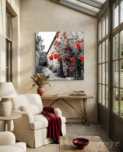 Red Roses Glass Wall Art displayed above wooden console table in cream stone sunroom with white armchair and burgundy throw.