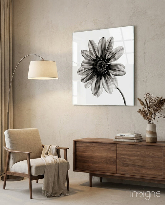 Monochrome daisy glass wall art displayed above a wooden dresser in a minimalist beige interior with mid-century furniture.