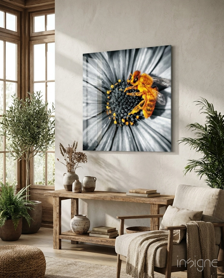 Bee Glass Wall Art mounted above wooden console table in bright room with plants, displaying yellow and black bee on flower with motion blur effect.