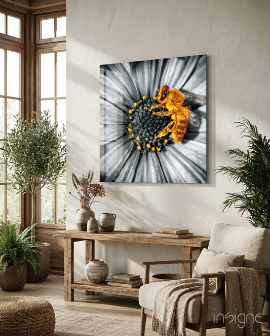 Bee Glass Wall Art mounted above wooden console table in bright room with plants, displaying yellow and black bee on flower with motion blur effect.