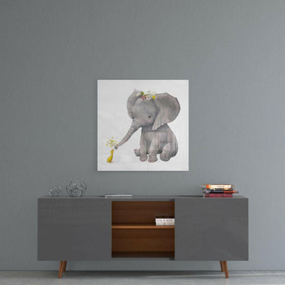 Square glass wall art depicting a gray elephant with flower crown offering flowers to a small yellow duck, displayed above a mid-century modern console table.