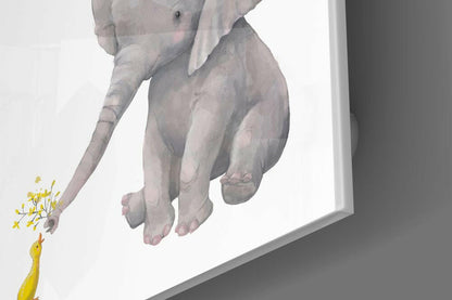 Glass wall art displaying a gray elephant's trunk gently touching a yellow duck against a white background.