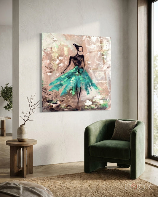 Glass wall art depicting silhouetted female figure in turquoise skirt against textured blush backdrop, displayed above green chair in modern interior.